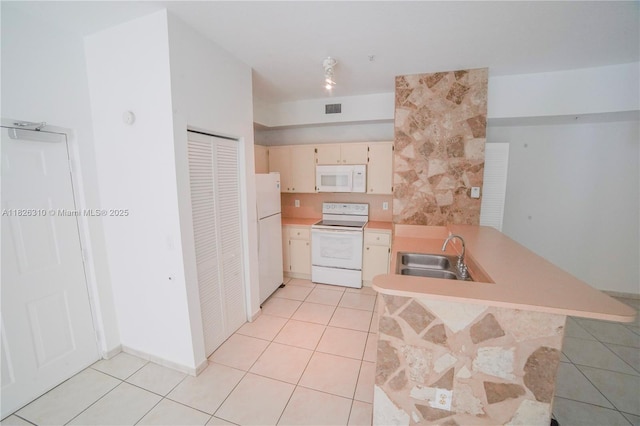 7200 NW 114th Ave Unit 305, Doral, FL 33178 - kitchen featuring white appliances, a peninsula, light tile patterned flooring, light countertops, and cream cabinetry