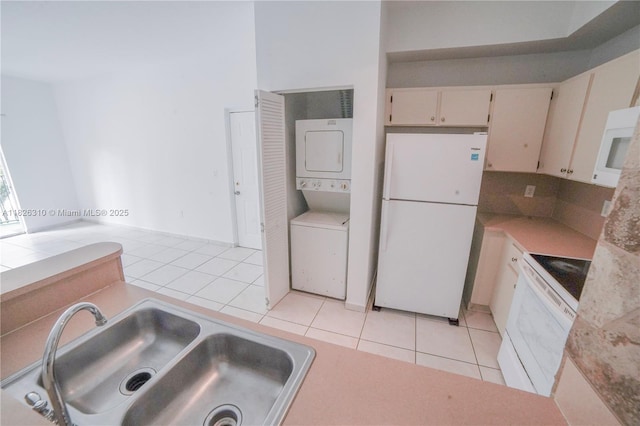 7200 NW 114th Ave Unit 305, Doral, FL 33178 - kitchen with white appliances, estacked washer and dryer, light tile patterned floors, and light countertops