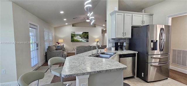 1948 Redmont Ave, Lehigh Acres, FL 33972 - kitchen featuring stainless steel appliances, lofted ceiling, a peninsula, open floor plan, and white cabinetry