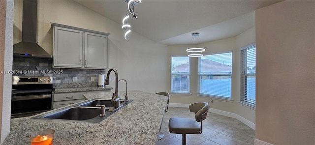 1948 Redmont Ave, Lehigh Acres, FL 33972 - kitchen featuring stainless steel range with electric stovetop, wall chimney exhaust hood, decorative backsplash, light tile patterned floors, and pendant lighting