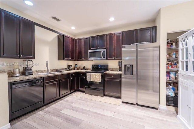 370 Lake Monterey Cir, Boynton Beach, FL 33426 - kitchen featuring black appliances, light wood-type flooring, recessed lighting, light stone countertops, and dark brown cabinets