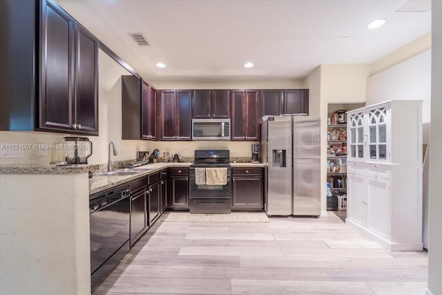 370 Lake Monterey Cir, Boynton Beach, FL 33426 - kitchen with black appliances, light wood-type flooring, light stone counters, dark brown cabinets, and recessed lighting