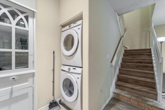 370 Lake Monterey Cir, Boynton Beach, FL 33426 - washroom with stacked washer / dryer and wood finished floors