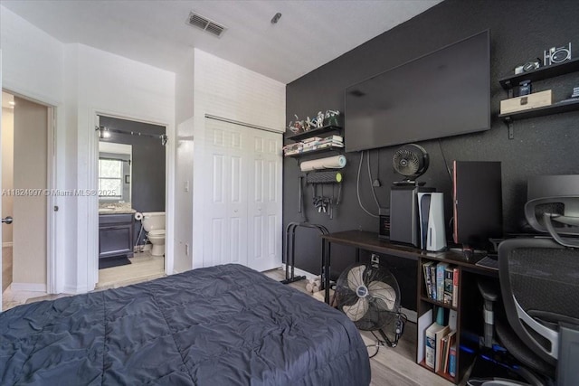 370 Lake Monterey Cir, Boynton Beach, FL 33426 - bedroom with light wood finished floors, a desk, a closet, and connected bathroom