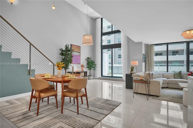 1111 SW 1st Ave Unit 721-N, Miami, FL 33130 - dining space with stairway, light tile patterned flooring, a towering ceiling, and expansive windows