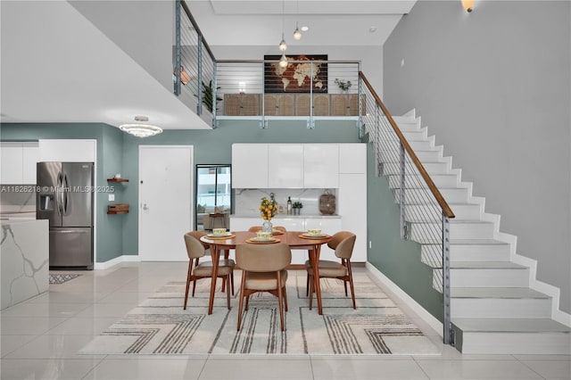 1111 SW 1st Ave Unit 721-N, Miami, FL 33130 - dining room featuring a towering ceiling, light tile patterned floors, and stairway