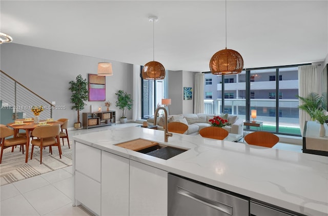 1111 SW 1st Ave Unit 721-N, Miami, FL 33130 - kitchen featuring stainless steel dishwasher, open floor plan, white cabinets, light tile patterned flooring, and light stone countertops
