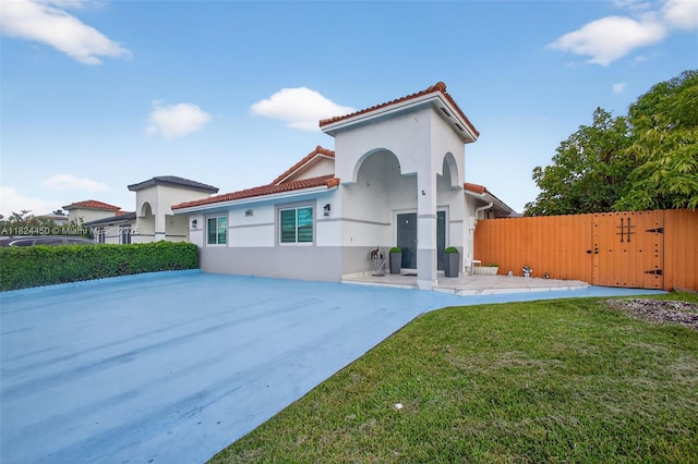 8905 NW 112th St, Hialeah Gardens, FL 33018 - view of front of home with a gate, stucco siding, a tile roof, and a patio area
