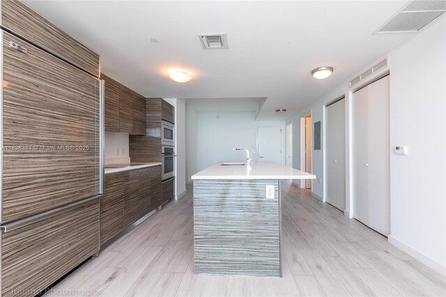 460 NE 28th St Unit 1905, Miami, FL 33137 - kitchen featuring modern cabinets, stainless steel appliances, light countertops, and an island with sink