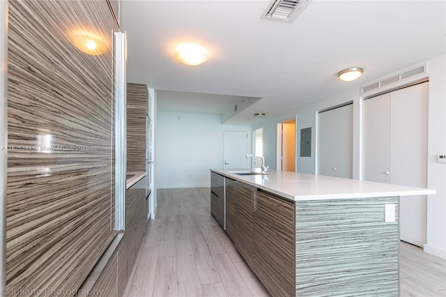 460 NE 28th St Unit 1905, Miami, FL 33137 - kitchen featuring modern cabinets, light wood-type flooring, light countertops, a center island with sink, and electric panel