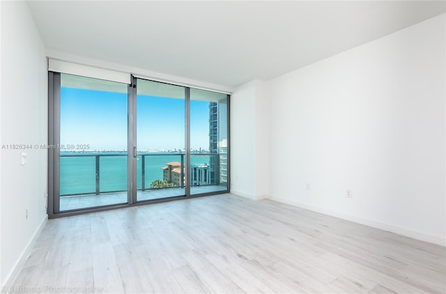 460 NE 28th St Unit 1905, Miami, FL 33137 - spare room featuring expansive windows, wood finished floors, and a water view