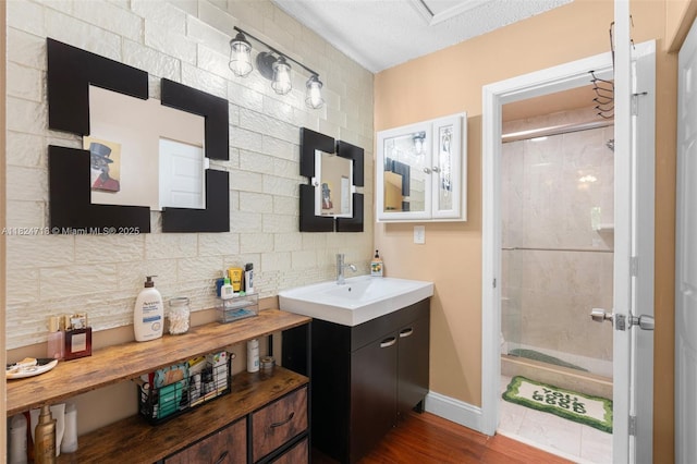602 Lincoln Ct Unit 602, Deerfield Beach, FL 33442 - bathroom with a stall shower, vanity, decorative backsplash, wood finished floors, and a textured ceiling