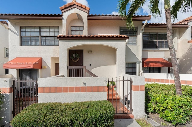 602 Lincoln Ct Unit 602, Deerfield Beach, FL 33442 - view of front of property featuring stucco siding, a tile roof, and a gate