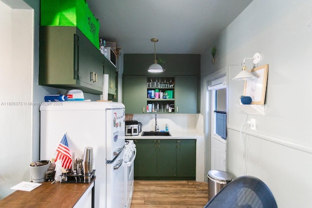 8420 Byron Ave Unit 6, Miami Beach, FL 33141 - kitchen featuring green cabinets, freestanding refrigerator, light wood finished floors, open shelves, and stainless steel microwave