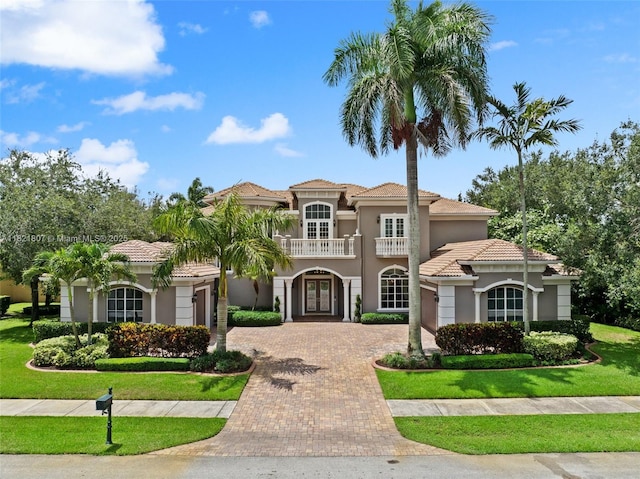 12608 S Stonebrook Cir, Davie, FL 33330 - mediterranean / spanish-style house featuring french doors, a balcony, decorative driveway, stucco siding, and a front yard