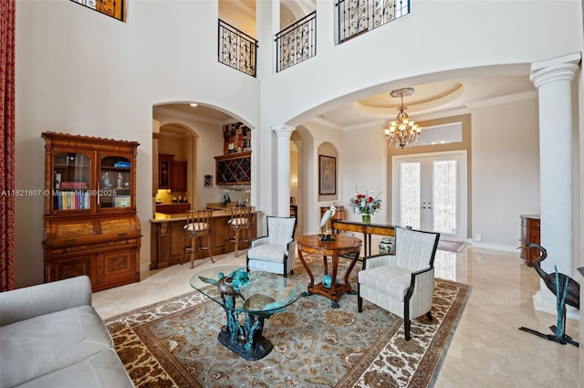 12608 S Stonebrook Cir, Davie, FL 33330 - living room featuring ornamental molding, a chandelier, decorative columns, arched walkways, and french doors