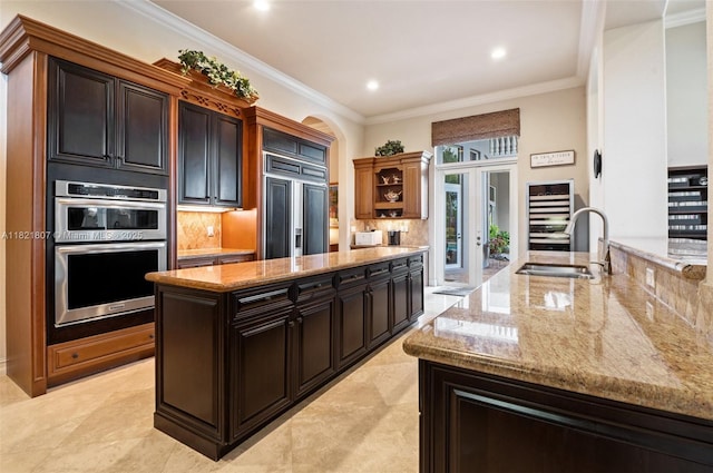 12608 S Stonebrook Cir, Davie, FL 33330 - kitchen featuring french doors, paneled fridge, beverage cooler, backsplash, and a center island