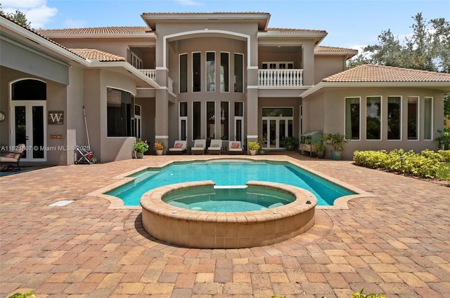 12608 S Stonebrook Cir, Davie, FL 33330 - back of property with french doors, stucco siding, a pool with connected hot tub, and a tile roof