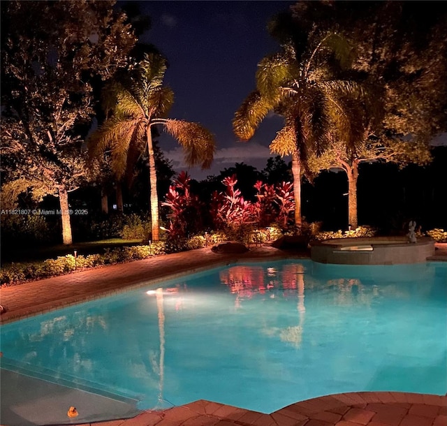 12608 S Stonebrook Cir, Davie, FL 33330 - pool at night featuring an outdoor pool and an in-ground hot tub