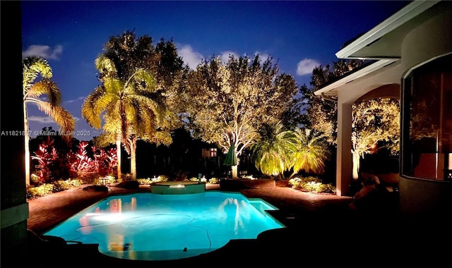 12608 S Stonebrook Cir, Davie, FL 33330 - pool at twilight featuring a pool with connected hot tub and a fenced backyard