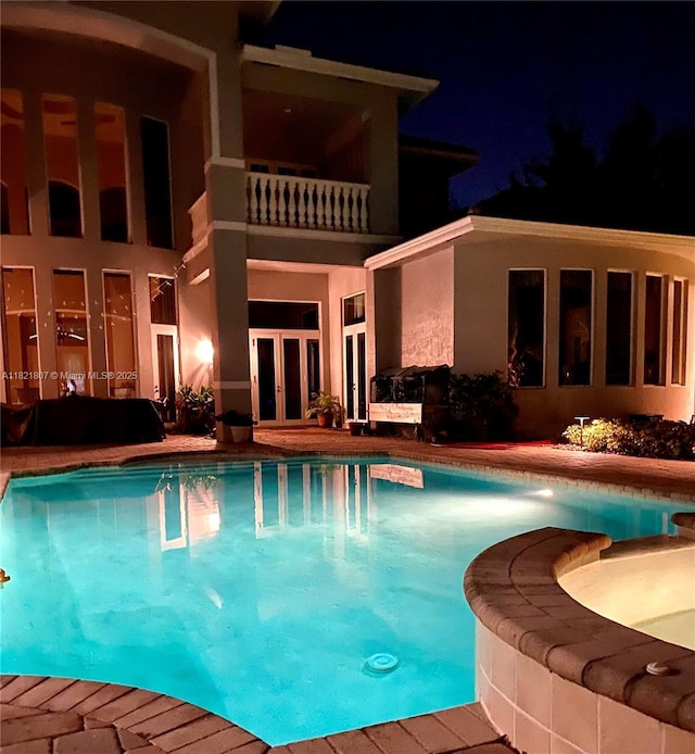 12608 S Stonebrook Cir, Davie, FL 33330 - pool at twilight featuring french doors and a pool with connected hot tub