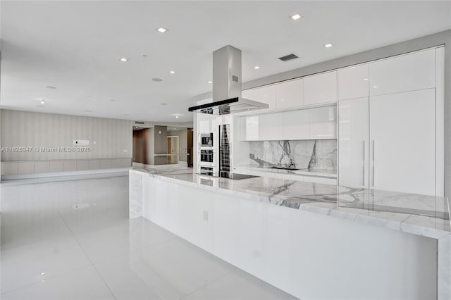 300 Sunny Isles Blvd Unit 4-Ts-04, Sunny Isles Beach, FL 33160 - kitchen featuring modern cabinets, island exhaust hood, white cabinets, stainless steel microwave, and light stone counters