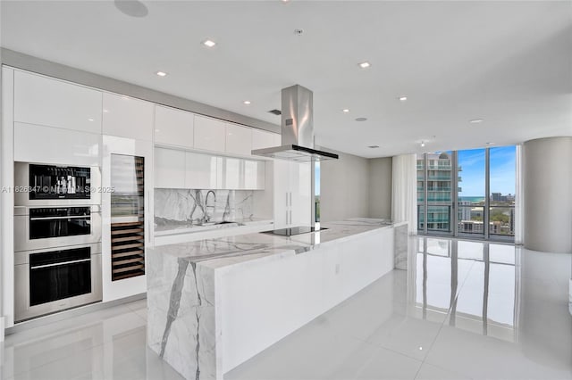 300 Sunny Isles Blvd Unit 4-Ts-04, Sunny Isles Beach, FL 33160 - kitchen featuring island exhaust hood, modern cabinets, white cabinetry, a wall of windows, and a large island