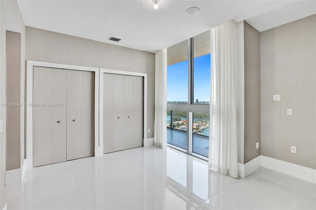 300 Sunny Isles Blvd Unit 4-Ts-04, Sunny Isles Beach, FL 33160 - unfurnished bedroom featuring multiple closets, tile patterned flooring, and access to exterior