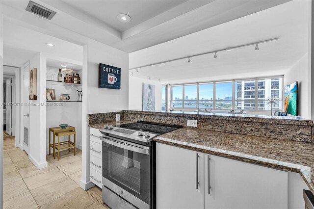11 Island Ave Unit 1103, Miami Beach, FL 33139 - kitchen featuring stainless steel range with electric stovetop, dark stone countertops, white cabinetry, and recessed lighting