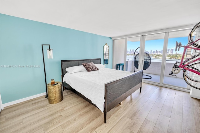 11 Island Ave Unit 1103, Miami Beach, FL 33139 - bedroom with light wood finished floors, access to outside, a skyline view, and expansive windows