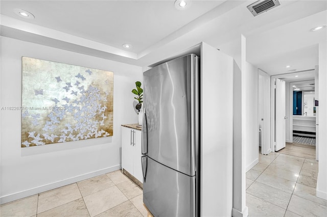 11 Island Ave Unit 1103, Miami Beach, FL 33139 - kitchen with freestanding refrigerator, recessed lighting, white cabinetry, and light marble finish floors