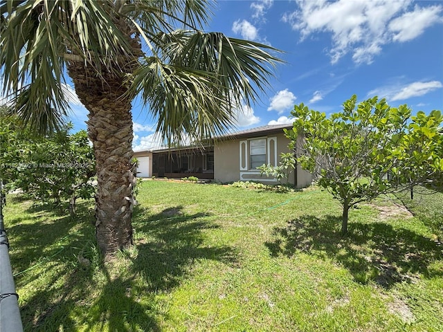 27064 Omni Ln, Punta Gorda, FL 33983 - view of green lawn featuring an attached garage