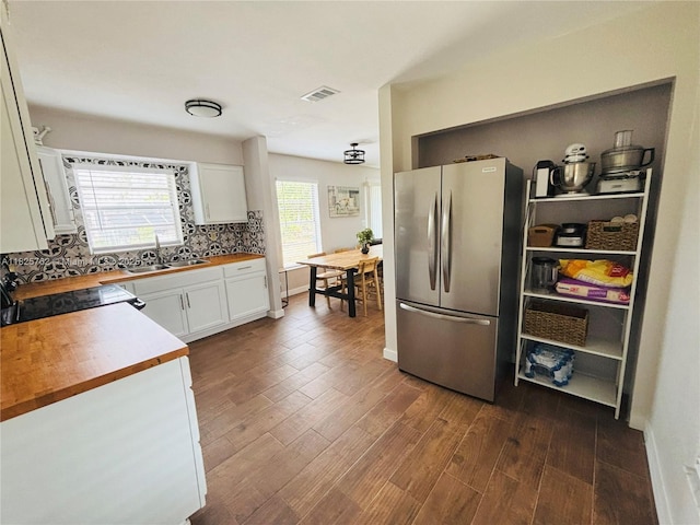 27064 Omni Ln, Punta Gorda, FL 33983 - kitchen with freestanding refrigerator, wood counters, dark wood-style floors, white cabinetry, and decorative backsplash
