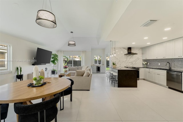 9248 Magnolia Ct, Davie, FL 33328 - kitchen with stainless steel appliances, wall chimney range hood, backsplash, beverage cooler, and dark countertops