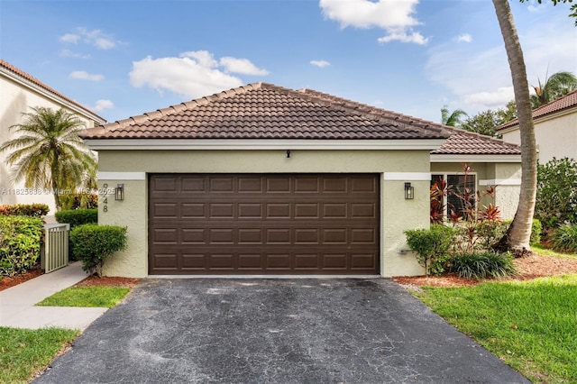 9248 Magnolia Ct, Davie, FL 33328 - mediterranean / spanish home with asphalt driveway, stucco siding, an attached garage, and a tile roof