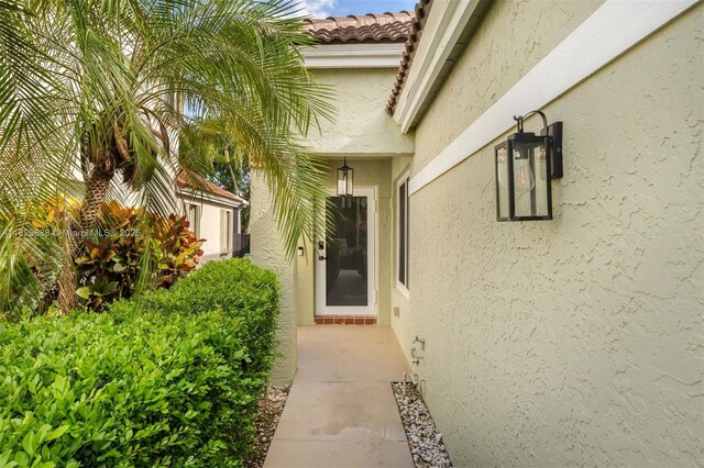 9248 Magnolia Ct, Davie, FL 33328 - doorway to property featuring stucco siding and a tiled roof