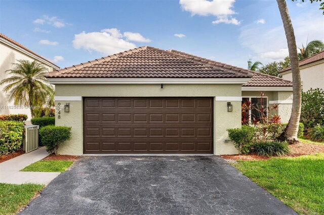 9248 Magnolia Ct, Davie, FL 33328 - mediterranean / spanish-style house featuring asphalt driveway, stucco siding, a garage, and a tile roof