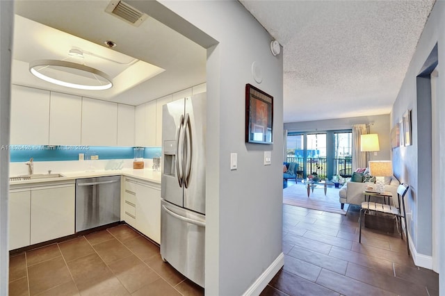 1201 S Ocean Dr Unit 218N, Hollywood, FL 33019 - kitchen with appliances with stainless steel finishes, dark tile patterned floors, light countertops, open floor plan, and a textured ceiling