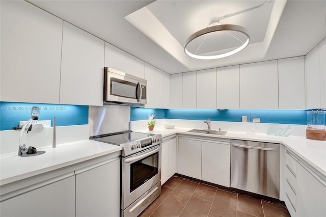 1201 S Ocean Dr Unit 218N, Hollywood, FL 33019 - kitchen featuring appliances with stainless steel finishes, light countertops, tile patterned flooring, white cabinets, and a raised ceiling