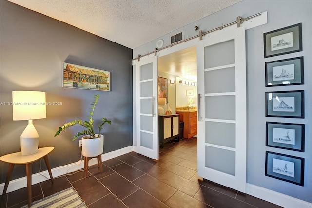 1201 S Ocean Dr Unit 218N, Hollywood, FL 33019 - living area featuring a textured ceiling, a barn door, and dark tile patterned flooring