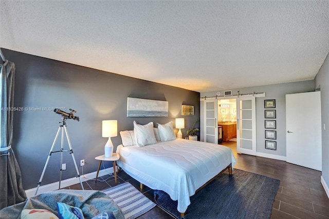 1201 S Ocean Dr Unit 218N, Hollywood, FL 33019 - bedroom with a barn door, a textured ceiling, and ensuite bathroom