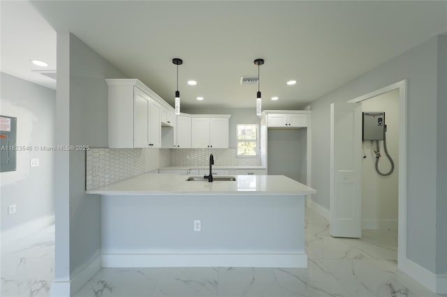 626 Hobart Ave S, Lehigh Acres, FL 33974 - kitchen with light marble finish flooring, a peninsula, recessed lighting, decorative backsplash, and white cabinetry
