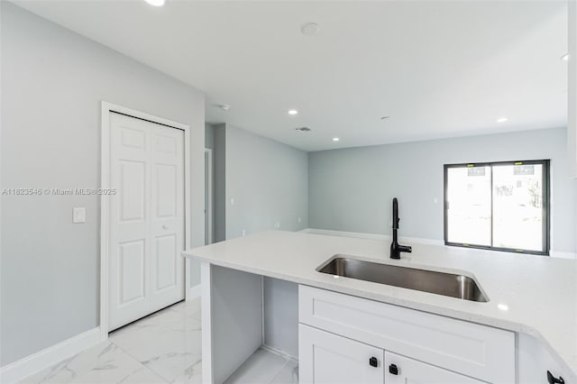 626 Hobart Ave S, Lehigh Acres, FL 33974 - kitchen with white cabinetry, light marble finish flooring, recessed lighting, and light stone counters