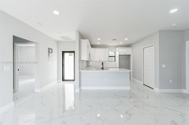 626 Hobart Ave S, Lehigh Acres, FL 33974 - kitchen featuring white cabinetry, recessed lighting, a peninsula, light countertops, and light marble finish floors