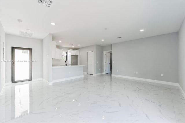 626 Hobart Ave S, Lehigh Acres, FL 33974 - unfurnished living room with recessed lighting and light marble finish flooring