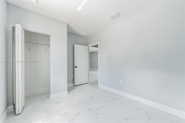 626 Hobart Ave S, Lehigh Acres, FL 33974 - unfurnished bedroom with marble look tile flooring and a closet
