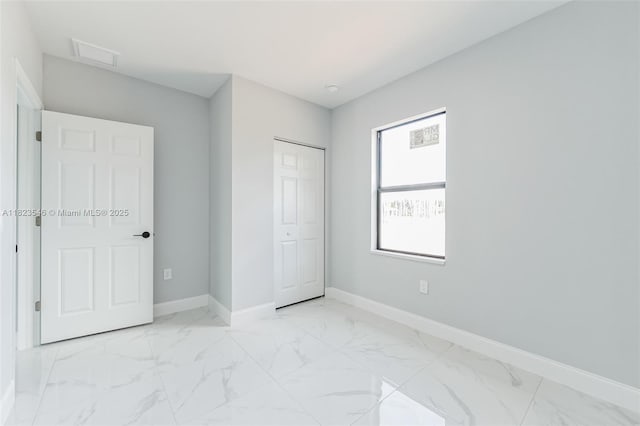 626 Hobart Ave S, Lehigh Acres, FL 33974 - unfurnished bedroom featuring light marble finish floors and a closet