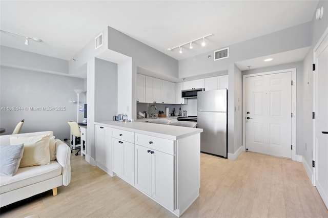 1621 Bay Rd Unit Ph3, Miami Beach, FL 33139 - kitchen with stainless steel appliances, rail lighting, light countertops, and a peninsula