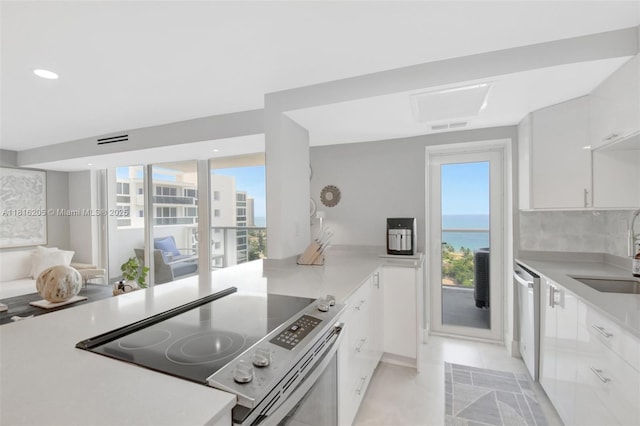 2701 N Ocean Blvd Unit 18A, Fort Lauderdale, FL 33308 - kitchen featuring appliances with stainless steel finishes, plenty of natural light, white cabinets, light countertops, and recessed lighting