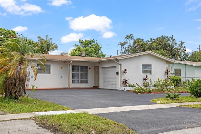 6441 NW 26th St, Sunrise, FL 33313 - ranch-style home featuring stucco siding, a garage, and asphalt driveway